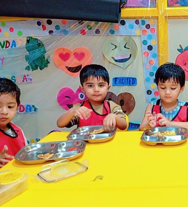 Children at the lunch table with their tiffin boxes
