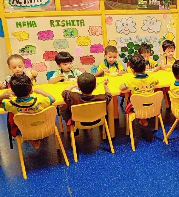 Children seated at yellow tables in the classroom